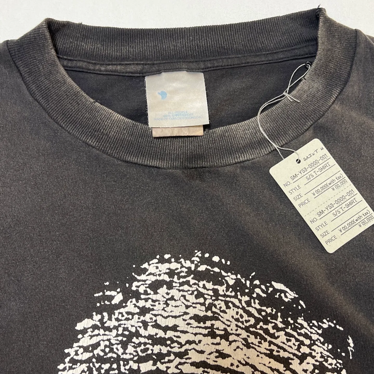 SAINT Mxxxxxx CHOSEN SS TEE/BLK Burst pattern/fingerprint print Chosen Tee Washed black S-XL Look for cylindrical fabrics without side seams. Don’t buy open-width fabrics anymore. It’s boring. Assute garment dyeing. Spray the whole piece with Ma Liu. Re-spray heavy fade. Collar and cuffs are frayed. Many places are broken. Authentic grade printing restored. Original consistent main mark/wash mark/with little angel anti-counterfeiting label.
